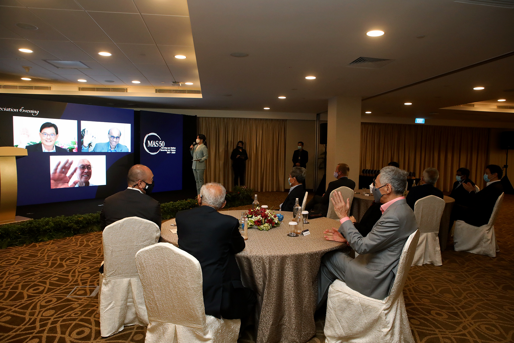 Prime Minister Lee Hsien Loong waving at the screen Mr Heng Swee Keat, Deputy Prime Minister and Board Member of MAS; Mr Tharman Shanmugaratnam, Senior Minister and Chairman of MAS; Mr Goh Chok Tong, Emeritus Senior Minister and Senior Advisor to MAS